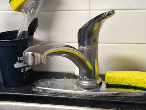 The continuous flow of water splashing against the sink